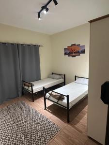 a room with two beds and a rug at Pousada Araquari in Paraty +1 photo