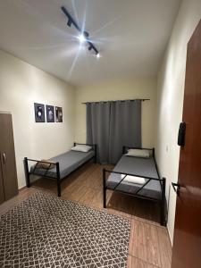 a room with two beds and a ceiling fan at Pousada Araquari in Paraty