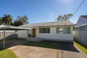 a white house with a patio in a yard at Casa Bella in Lakeside