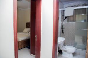 a bathroom with a toilet and a sink and a bed at A Beautiful home, Kanombe, Nyarugunga in Kigali +13 photos