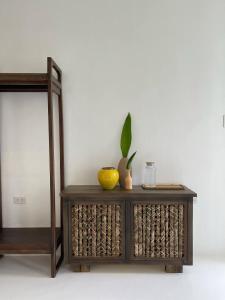 a wooden console table with a mirror and a plant on it at The KAZA Boutique Hotel in General Luna