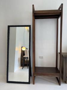 a mirror with a wooden frame next to a chair at The KAZA Boutique Hotel in General Luna +89 photos
