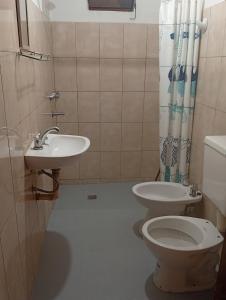 a bathroom with a toilet and a sink at Alojamiento Valle del Sol in San Fernando del Valle de Catamarca