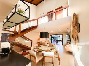 ein Esszimmer und ein Wohnzimmer mit einer Wendeltreppe in der Unterkunft Bangalô Essenza do Sol |Luxo & Charme em Carneiros in Tamandaré