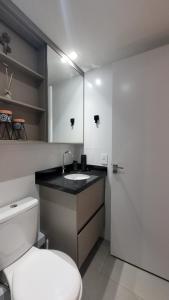 une salle de bain avec toilettes, lavabo et miroir dans l'établissement Design e conforto próximo ao Shopping e USP - HRAC, à Bauru
