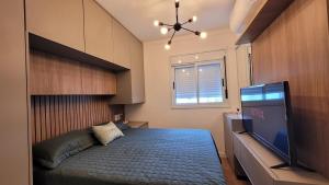 une chambre avec un lit et une télévision à écran plat dans l'établissement Design e conforto próximo ao Shopping e USP - HRAC, à Bauru