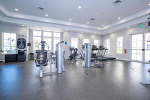 a gym with treadmills and machines in a room at Magic Villa Orlando in Orlando
