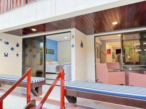 ein Balkon mit einer Bank und ein Zimmer mit einem Bett in der Unterkunft Nannai Residence Muro Alto Porto Galinhas BeiraMar in Porto De Galinhas