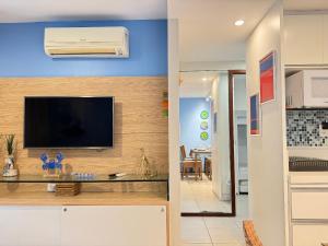 ein Wohnzimmer mit einem Flachbildfernseher an der Wand in der Unterkunft Nannai Residence Muro Alto Porto Galinhas BeiraMar in Porto De Galinhas