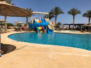 a large swimming pool with a water slide in a resort at Sunset Sahl Hashesh in Hurghada