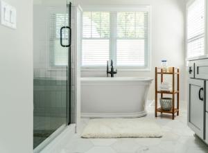 Un baño blanco con bañera y ventana. en Tranquil Family Retreat - for 10, en Lake Geneva