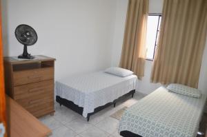 a bedroom with two beds and a dresser and a window at Apto 2 dormitórios 1 banheiro 1 vaga descoberta in Piracicaba
