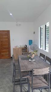 Un comedor con mesa y sillas de madera. en HYD Hostel Moalboal, en Moalboal
