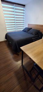 a bedroom with a bed and a table and a window at Monoambiente 12 in La Paz