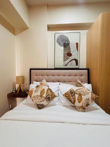 a bedroom with a bed with white sheets and pillows at A Dreamy Elegant Studio in Mandurriao