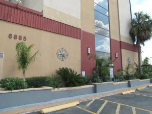 ein Parkplatz vor einem Gebäude mit Palmen in der Unterkunft Romana Hotel - Houston Southwest in Houston