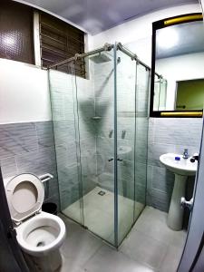 a bathroom with a shower and a toilet and a sink at Hotelobelisq in Medellín
