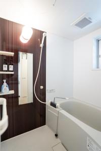un baño con lavabo y bañera en Maxim 2-B, en Naha