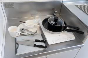 Una encimera de cocina con una sartén sobre una estufa en Maxim 2-B, en Naha