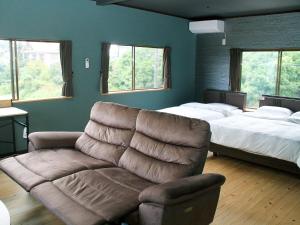 ein Wohnzimmer mit einer Couch und einem Bett in der Unterkunft 久遠霧島 in Kirishima