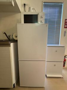 Un refrigerador blanco en una cocina con microondas. en Maxim 2-B, en Naha 12 fotos más