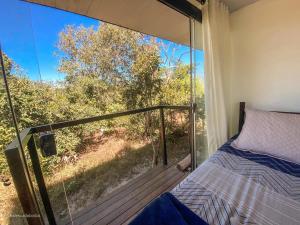 a bedroom with a bed on a deck at Casa Borba Chalé e rio privativo in Alto Paraíso de Goiás