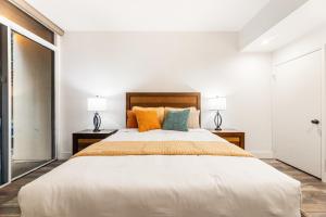a bedroom with a large bed with two lamps at Spacious 2 Bedroom Condo in DTLA, Large Private Patio, Pets Welcomed in Los Angeles