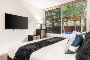 a bedroom with a bed and a large window at Spacious 2 Bedroom Condo in DTLA, Large Private Patio, Pets Welcomed in Los Angeles
