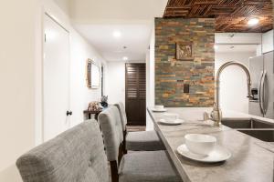 a kitchen with a counter with chairs and a sink at Spacious 2 Bedroom Condo in DTLA, Large Private Patio, Pets Welcomed in Los Angeles +32 photos