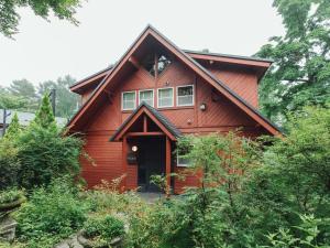 a red house with a black door at Izumigo AMBIENT Yatsugatake Cottage in Hokuto