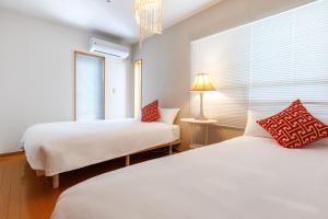 a bedroom with two beds and a window at 本部町Mio Styleは美ら海水族館まで10分の好立地の一棟貸BBQ可能 in Motobu