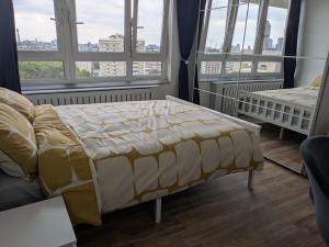 Stylish 1 Bedroom Flat in Old Street في لندن: غرفة نوم بسرير واريكة ونوافذ