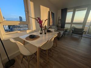 Stylish 1 Bedroom Flat in Old Street في لندن: غرفة معيشة مع طاولة وكراسي في غرفة