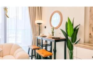 een woonkamer met een tafel en een spiegel bij Modern Studio in Al Maryah Vista in Abu Dhabi