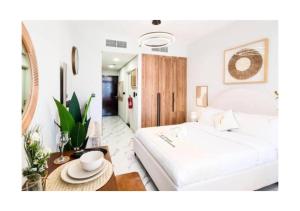 een slaapkamer met een groot wit bed en een tafel bij Modern Studio in Al Maryah Vista in Abu Dhabi +23 foto's