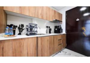 een keuken met houten kasten en een aanrechtblad bij Modern Studio in Al Maryah Vista in Abu Dhabi