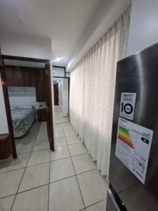 ein Zimmer mit einem Schlafzimmer mit einem Bett und einem Kühlschrank in der Unterkunft Cajamarca House in Cajamarca