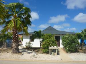 a white house with palm trees in front of it at AquaVilla Bonaire in Kralendijk