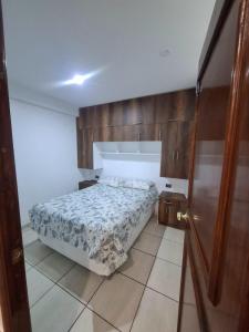 ein kleines Schlafzimmer mit einem Bett und Holzschränken in der Unterkunft Cajamarca House in Cajamarca