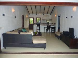 a living room with two couches and a kitchen at AquaVilla Bonaire in Kralendijk