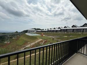 a balcony with a view of a field and a building at Wind Hill Mountain View Resort in Gununggeulis