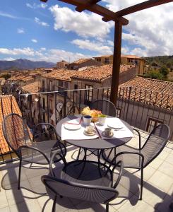 un tavolo e sedie su un balcone con vista di Case Spazioscena - Euterpe a Castelbuono