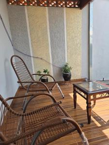 a chair and a coffee table on a porch at Casa aconchegante A , 4 minutos do thermas in Andradina