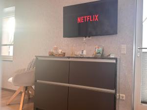 a television on a wall above a dresser at WILD&COZY Apartment mit moderner Küche & Terrasse in Blankenburg +8 photos