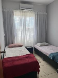 a bedroom with two beds and a window at O melhor e + aconchegante AP de SPA (custo/benefício) in São Pedro da Aldeia +23 photos