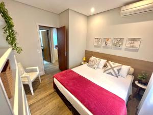a bedroom with a large bed with a red blanket at Casa Cozy - Excelente Localização in Piracicaba