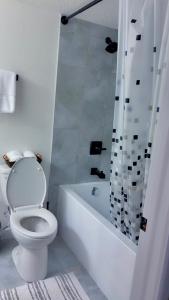 a white bathroom with a toilet and a shower at Lucas in Edmonton +5 photos