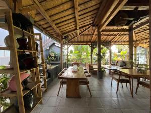 a dining room with wooden tables and chairs at Villa Alisha in Canggu