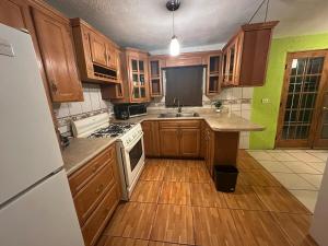 a kitchen with wooden cabinets and a white stove top oven at House by American Consulate Cd in Manuel F. Martínez