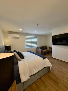 a bedroom with a large bed and a couch at Casa al Mare in Mazatlán